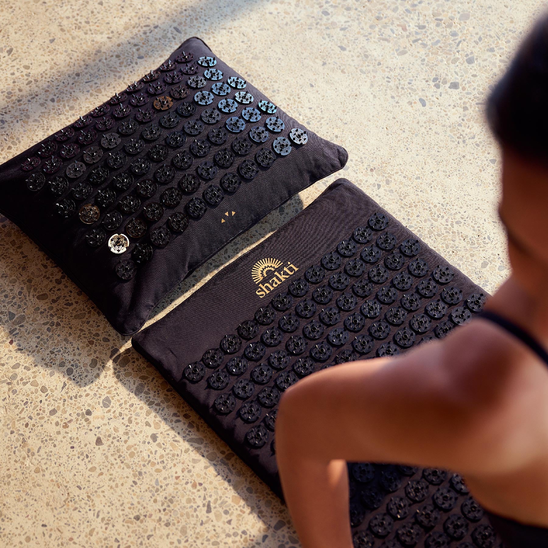 Black Level 4 acupressure mat with on a polished concrete floor